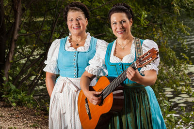 Portrait of smiling women playing guitar