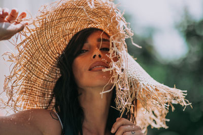 Close-up portrait of a young woman wearing hat