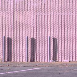 Poles against pink wall