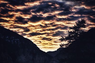 Scenic view of dramatic sky over silhouette mountain