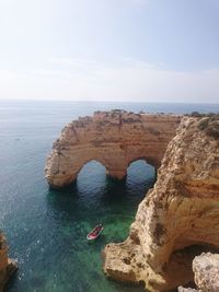 Rock formation in sea against sky