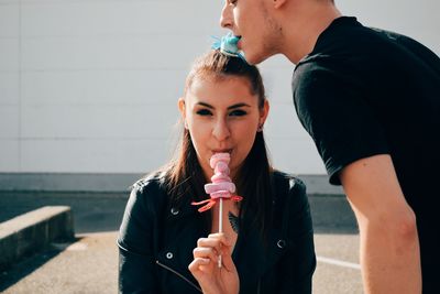 Young woman holding ice cream standing outdoors