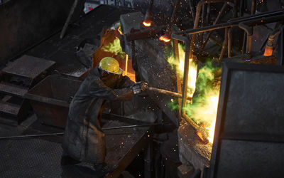 Industry, worker at furnace during melting copper, wearing a fire proximity suit