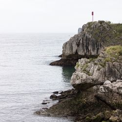 Rock formation on sea against sky