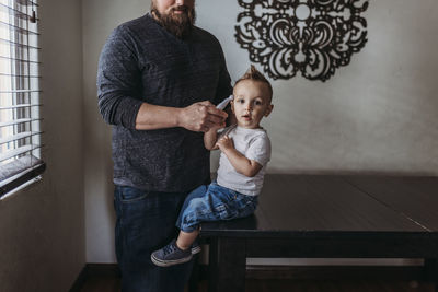 Midrange view of father taking young sons temperature at home