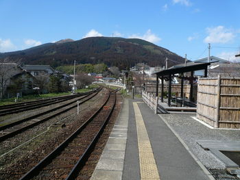 Railroad track by mountain against sky