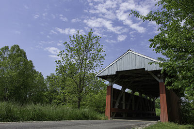 House by trees in forest against sky