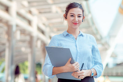 Portrait of a smiling young woman using mobile phone