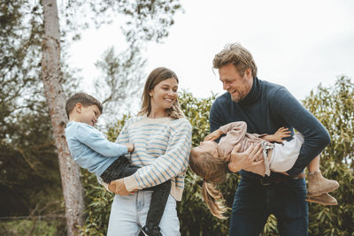 Playful parents with daughter and son in nature