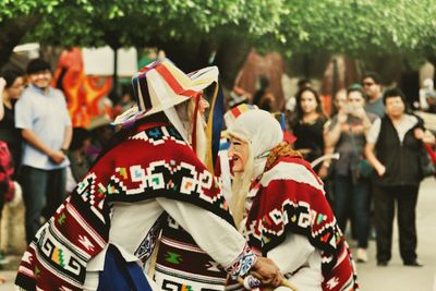 People in costume performing on street during carnival