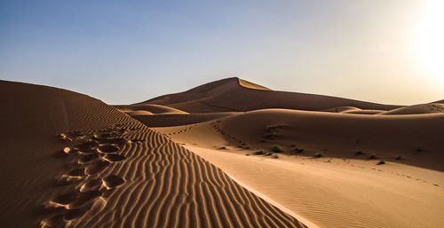 Sand dunes in desert against sky