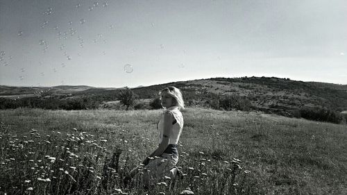 Woman standing on field against sky