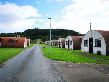 Road by buildings against sky in city