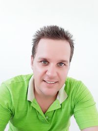 Portrait of smiling young man against white background