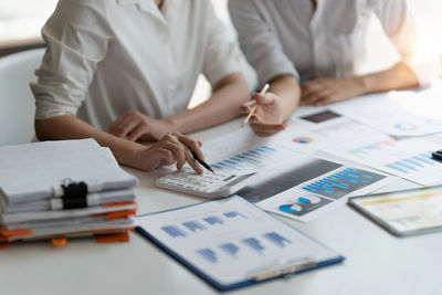 Midsection of business colleagues brainstorming at office