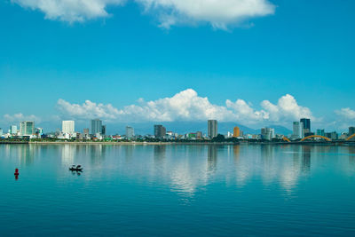 City by sea against blue sky