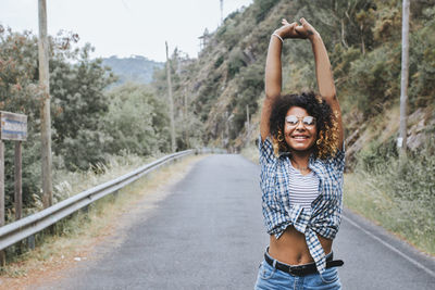 Girl enjoying outdoors with arms aloft