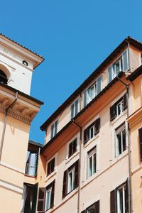 Low angle view of residential buildings against clear blue sky
