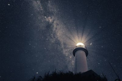 Low angle view of lighthouse against sky at night