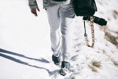 Low section of man standing on snow