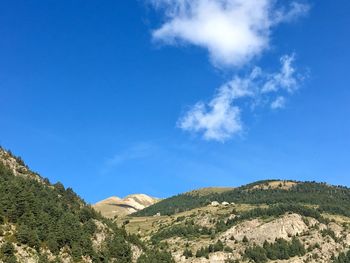 Low angle view of mountain against blue sky