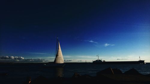 Sailboats in sea against sky