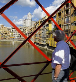 Side view of senior man looking at girona cathedral through railing