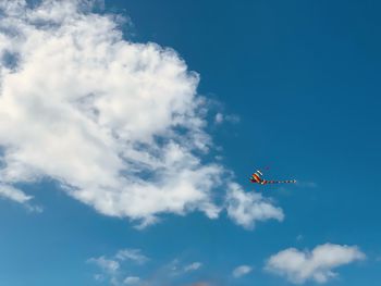 Low angle view of a kite flying against blue sky