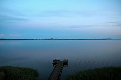 Scenic view of calm lake against sky during sunset