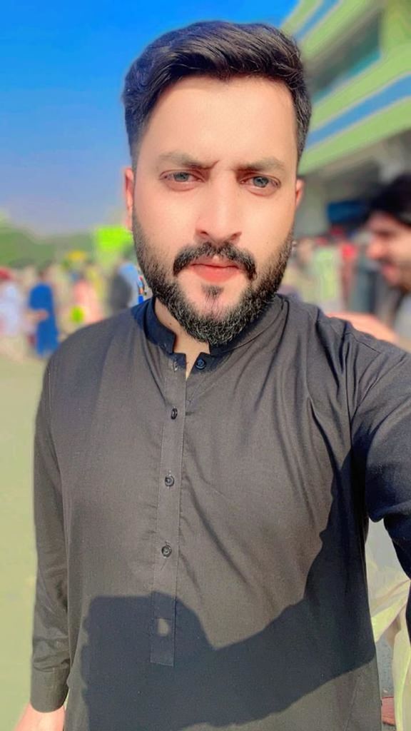beard, facial hair, one person, portrait, men, adult, looking at camera, human hair, waist up, front view, young adult, casual clothing, person, focus on foreground, standing, arts culture and entertainment, hairstyle, clothing, lifestyles, human face, brown hair, leisure activity, emotion, day, city, outdoors, stubble, smiling