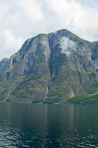 Scenic view of lake by mountain against sky