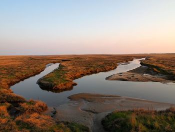 Scenic view of landscape against clear sky during sunset