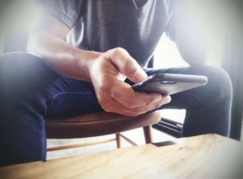 Close-up of man sitting on table at home