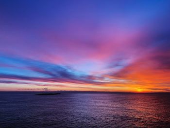 Scenic view of sea against dramatic sky during sunset