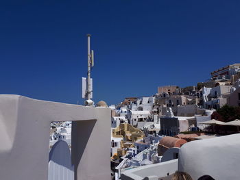 Buildings in city against clear blue sky