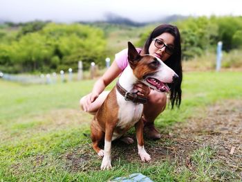 Young woman with bull terrier on field