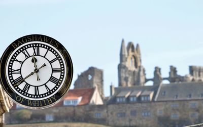 Close-up of clock tower against buildings in city