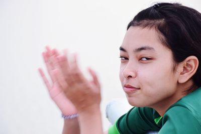 Close-up portrait of boy looking away against white background