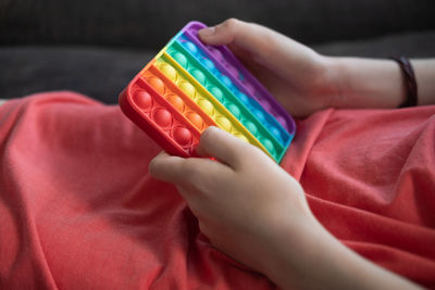 Close-up of hands holding multi colored baby