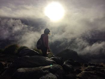 Man on rock against sky