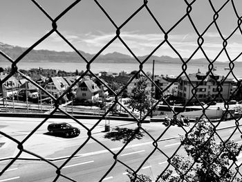 View of cityscape seen through chainlink fence