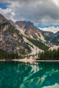 Scenic view of lake by mountains against sky