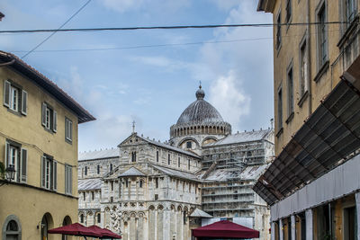 Low angle street view of the pisa cathedral building in tuscany, italy.