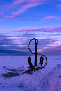 Silhouette person on snow field during sunset