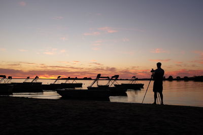 Silhouette of boat in sea at sunset