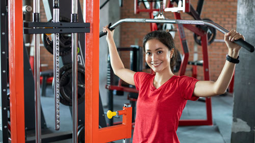 Portrait of young woman exercising in gym