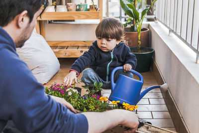 Boy and woman holding while sitting on floor