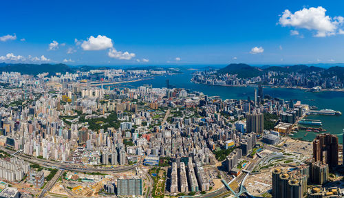 High angle view of buildings by sea against blue sky