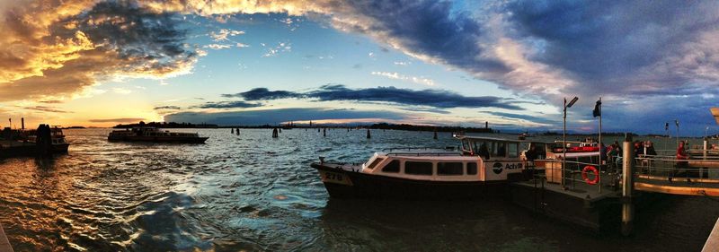 Boats moored on sea against sky during sunset