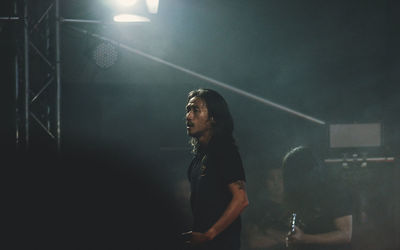 Side view of young man looking away at night